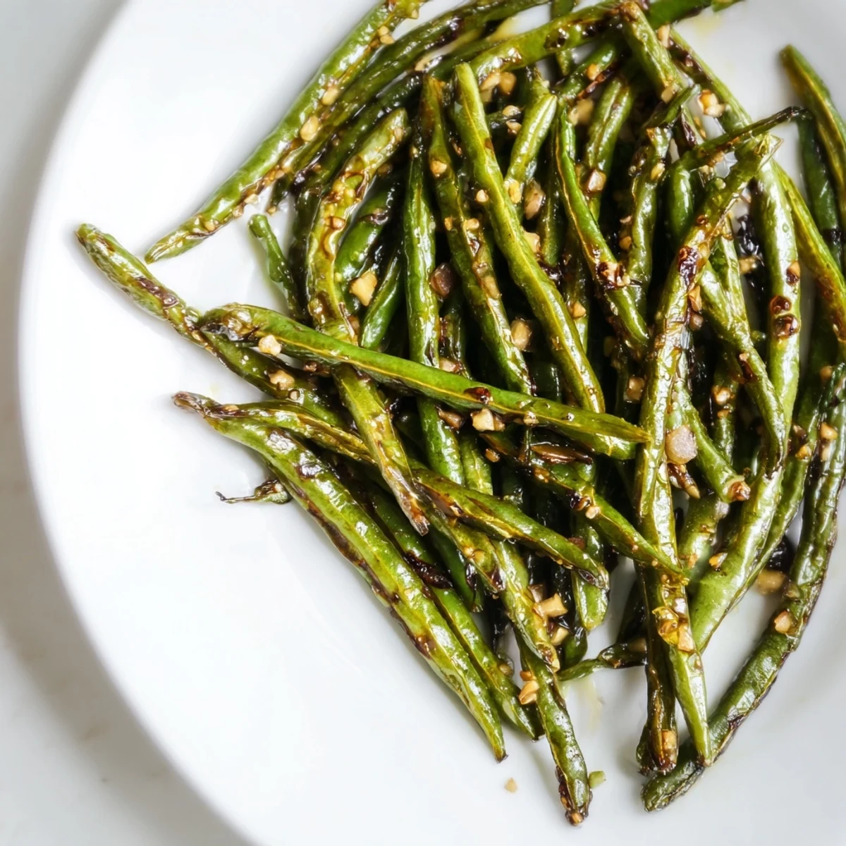A close-up of vibrant Garlic Roasted Green Beans, glistening with olive oil and perfectly roasted.