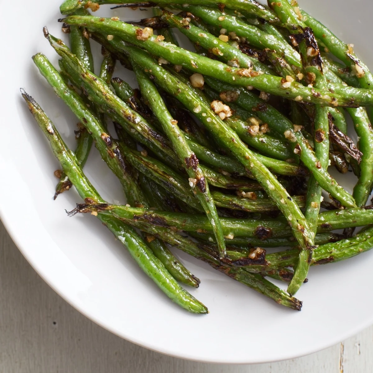 Freshly made Garlic Roasted Green Beans, sprinkled with spices, offering a flavorful and vegan meal.