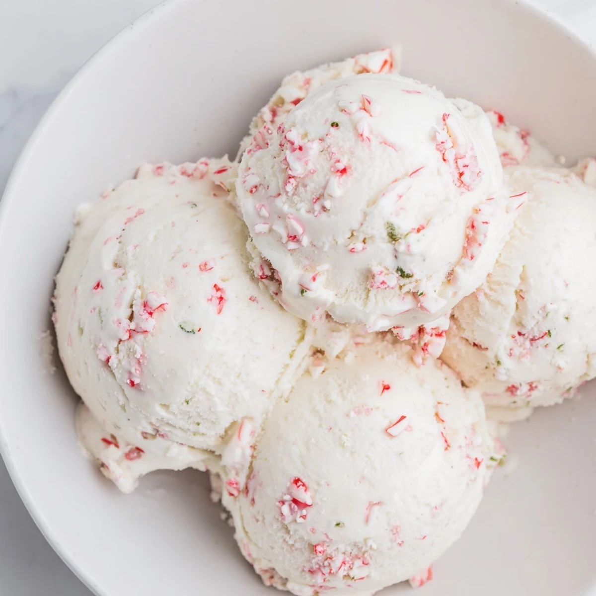 Scoopable Peppermint Ice Cream in a bowl: a refreshing, minty dessert for a summer treat.