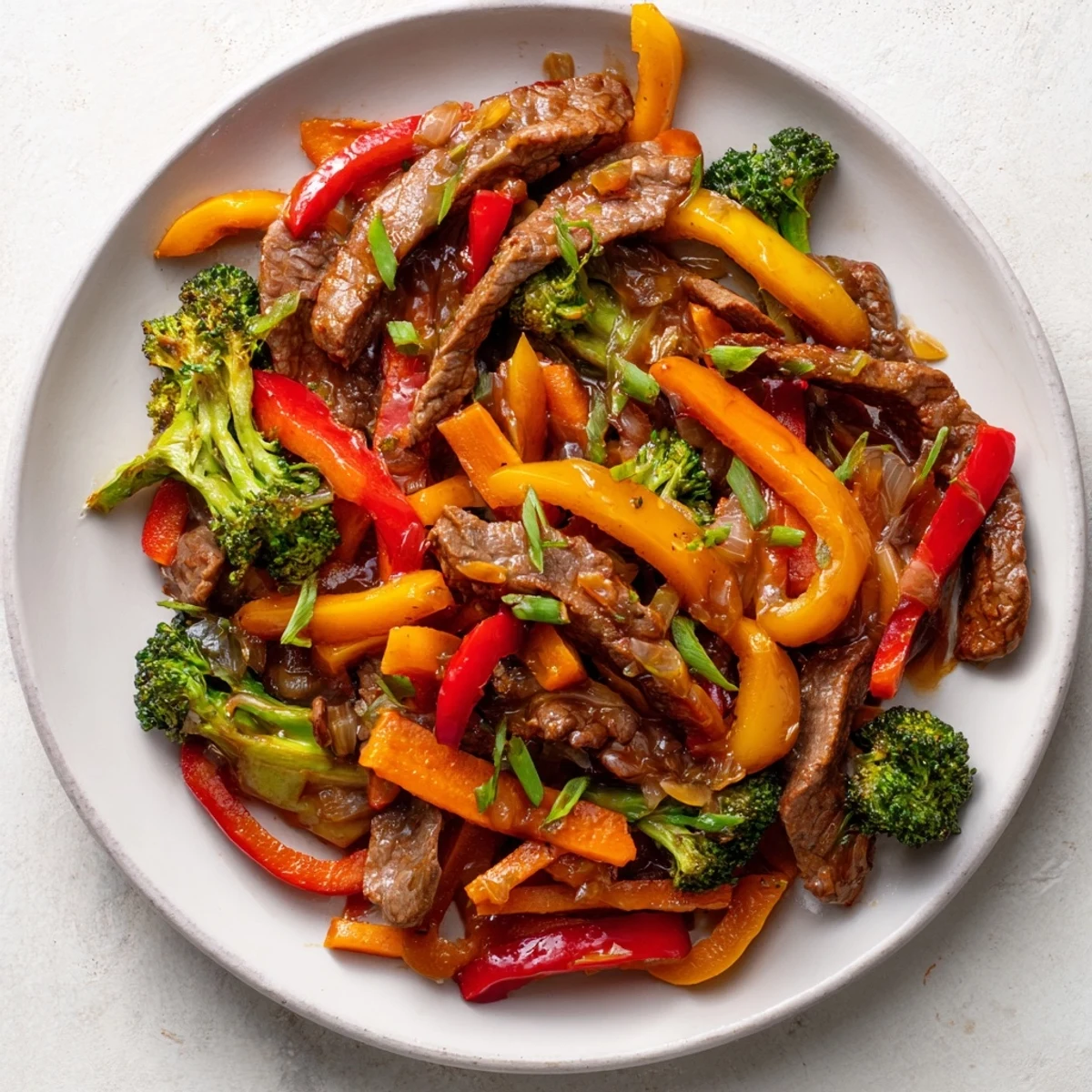 A steaming bowl of beef stir fry, highlighting strips of beef and crisp bell peppers.