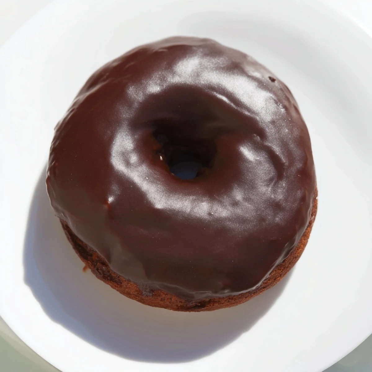 Warm, freshly baked chocolate donuts; a decadent treat glistening with a rich chocolate glaze.