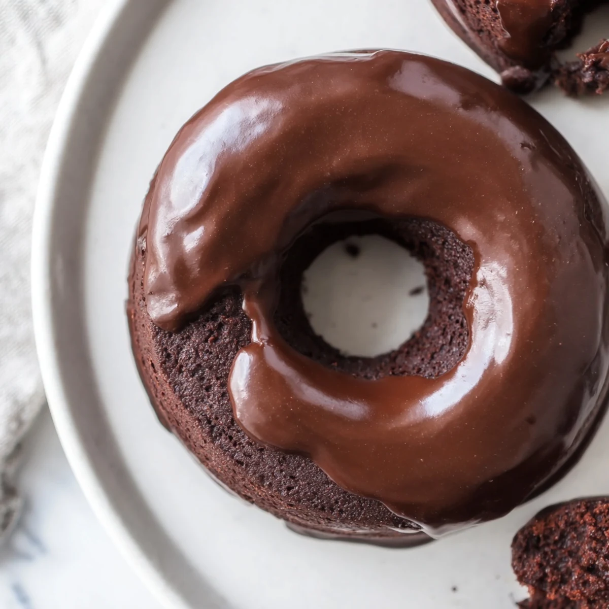 These homemade chocolate donuts, lightly dusted, are ready for a morning delight with coffee.
