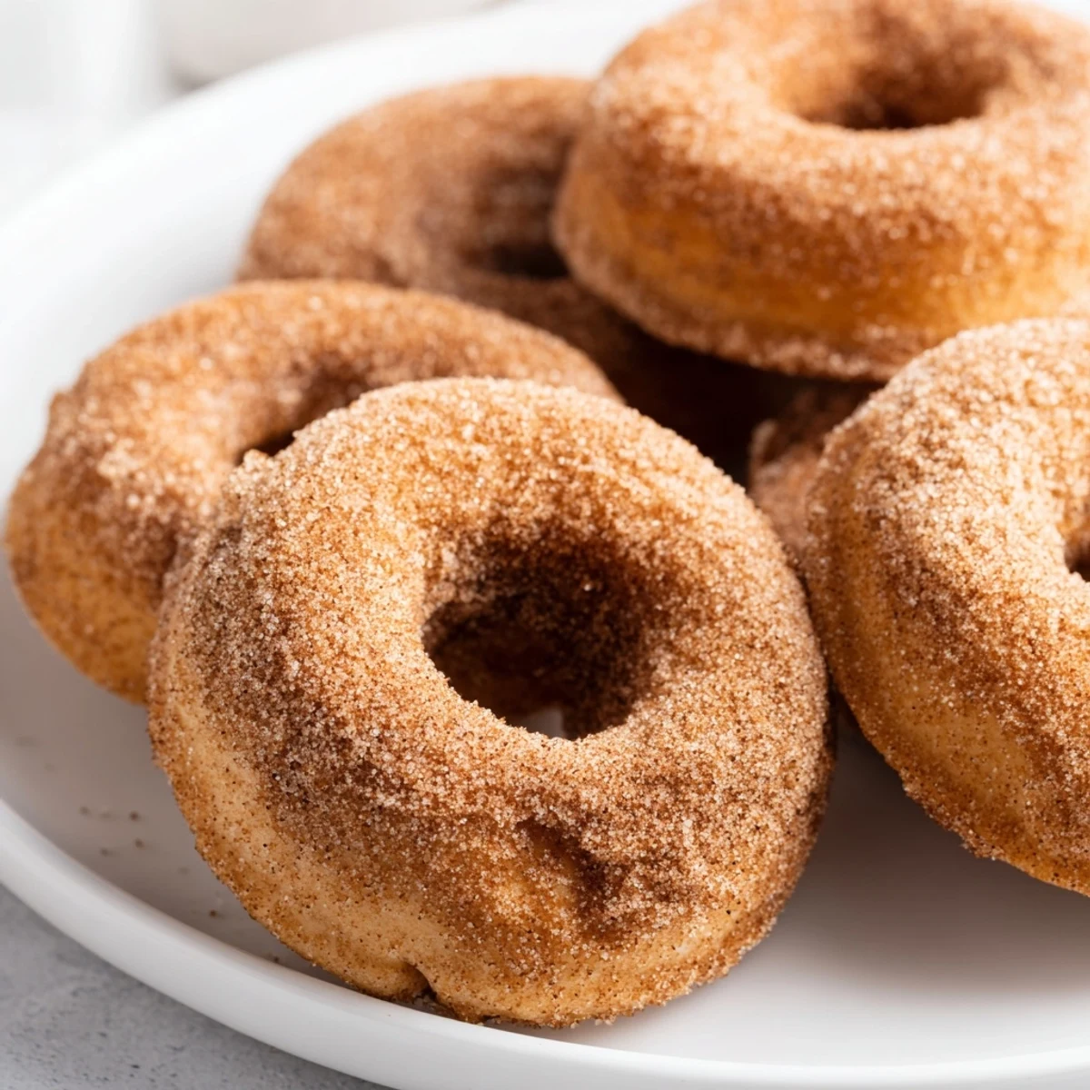 Warm, golden cinnamon sugar donuts, fresh from the fryer, dusted with a sweet, spiced coating.