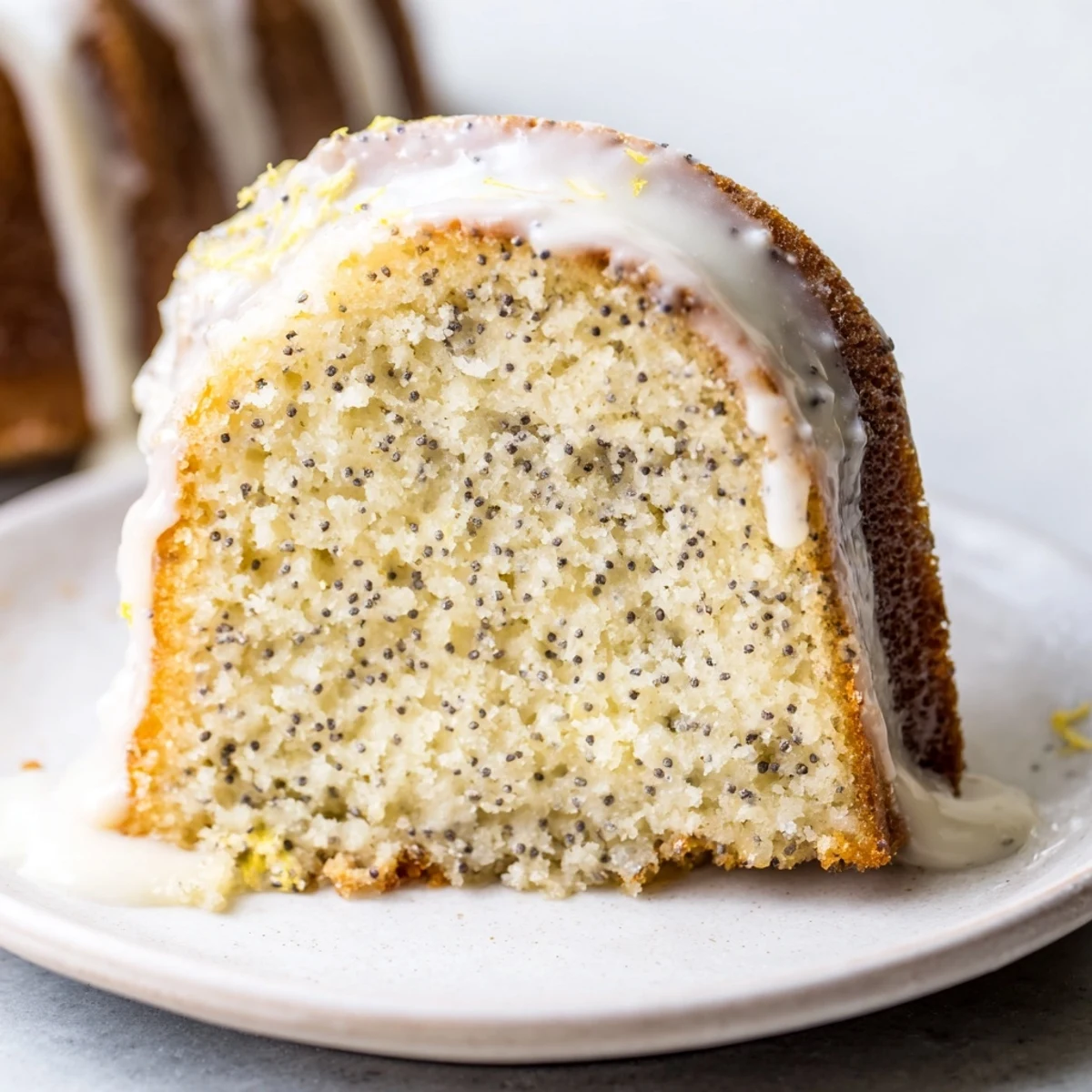 Warm Lemon Poppy Seed Bundt Cake on a cooling rack, drizzled with zesty glaze, ready for a brunch spread.