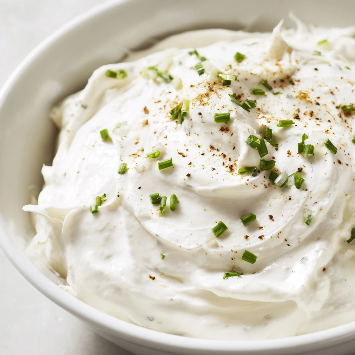 The rich Creamy Dip Bowl in a ceramic dish, set beside colorful veggie sticks and gluten-free crackers on a bright kitchen counter.