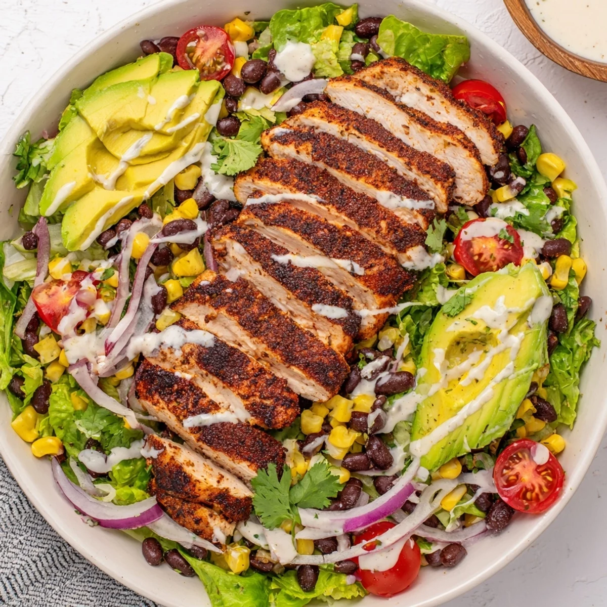 Close-up of Southwest Chicken Salad with Chipotle Lime Dressing, showing a bowl filled with crisp lettuce, juicy tomatoes, and shredded cheese.