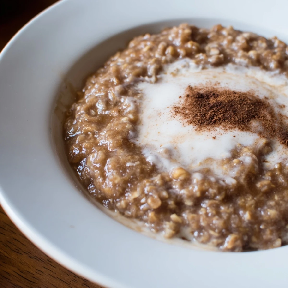 Steaming Irish Oatmeal with Brown Sugar and Cream topped with a drizzle of heavy cream and a dusting of cinnamon.