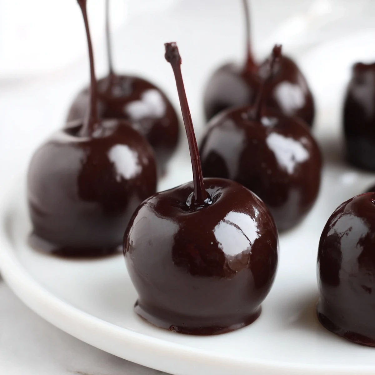 These Chocolate Covered Cherries with Fondant Center feature glossy dark chocolate shells around creamy fondant and maraschino cherries.