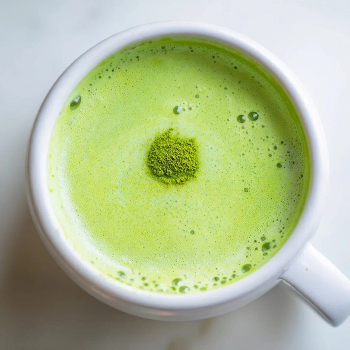 A vibrant matcha latte with oat milk and honey, shown beside ingredients for a homemade preparation.  