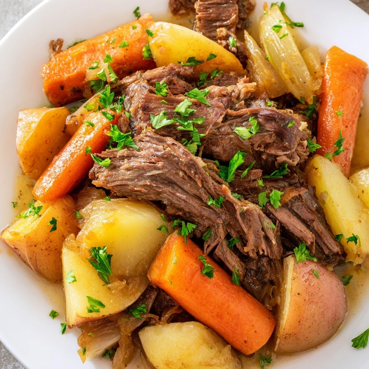 Slow cooker beef pot roast with root vegetables, carrots and potatoes glistening in savory broth on a platter.