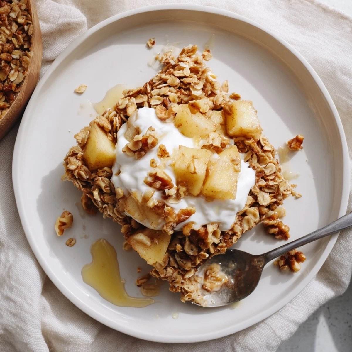 Overhead view of a serving of baked apple oatmeal with Greek yogurt, dusted with cinnamon and perfect for a cozy breakfast.