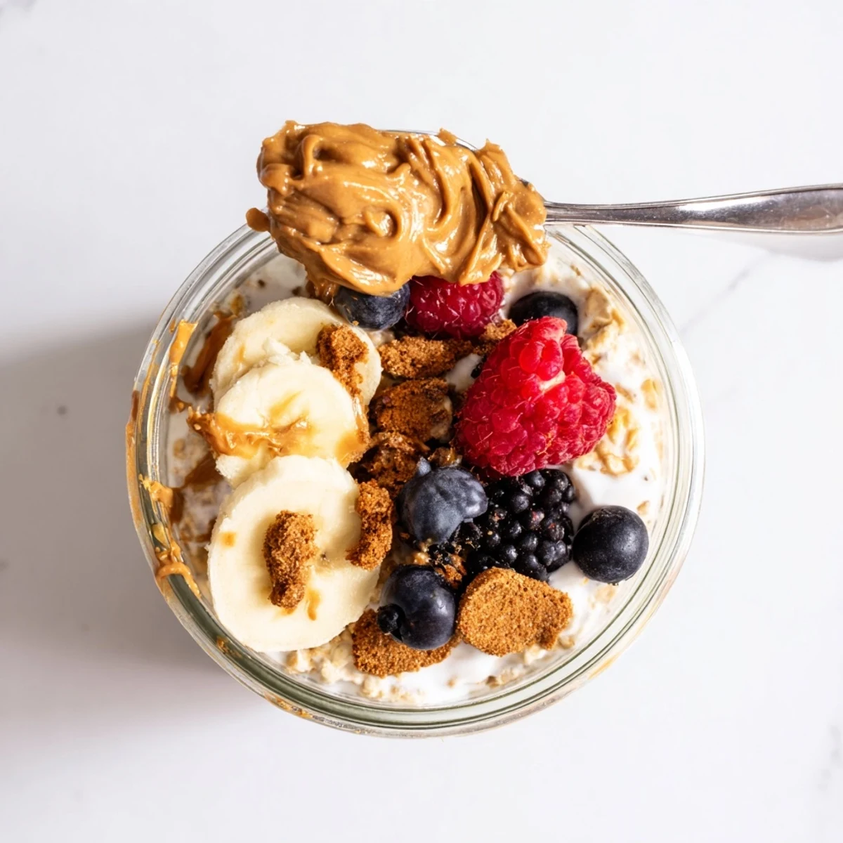 Quick Biscoff Overnight Oats with a drizzle of melted Biscoff spread, fresh berries, and a cozy morning coffee on the side.