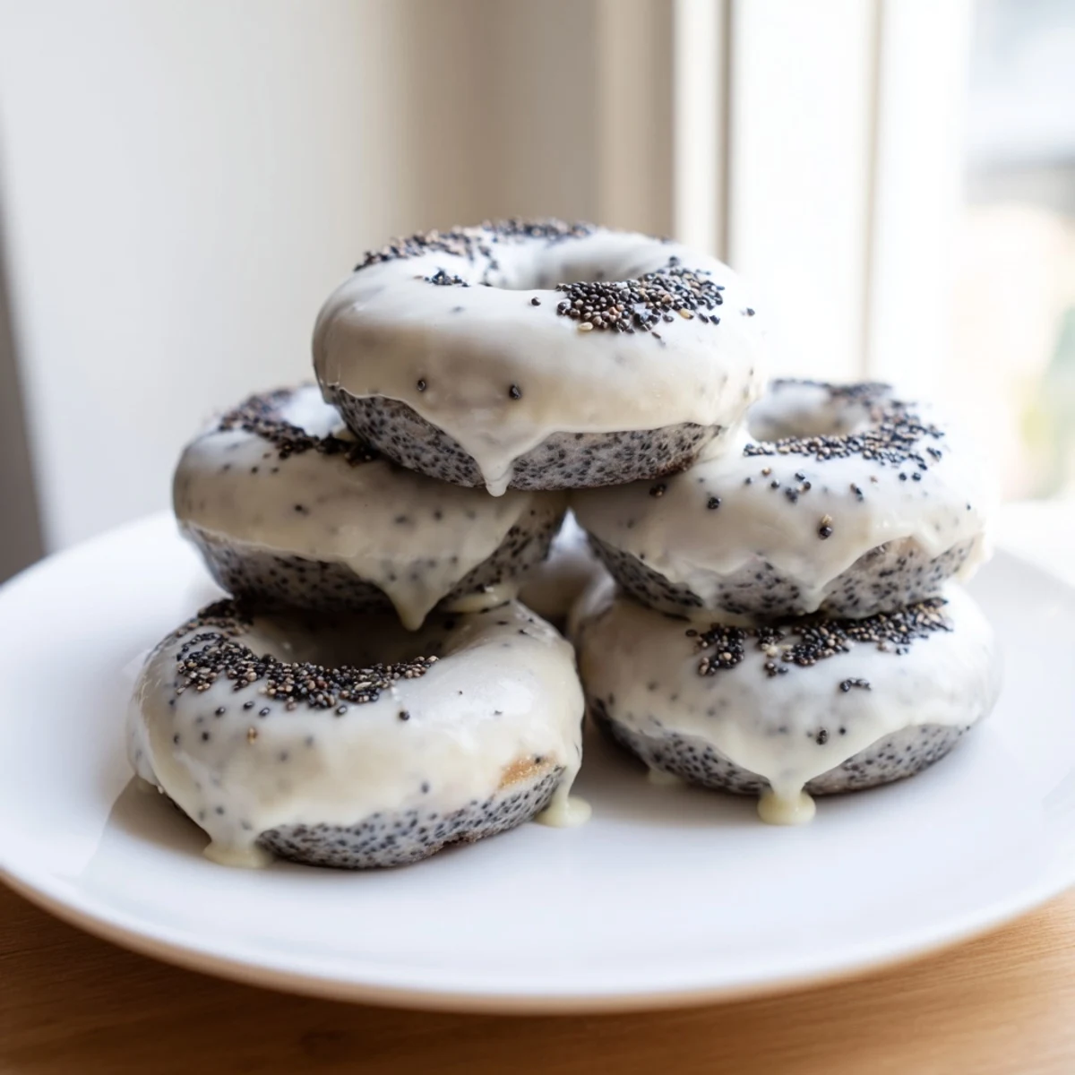 Golden-brown Black Sesame Mochi Donuts with a crackly glaze and sesame topping sit on a wooden board.