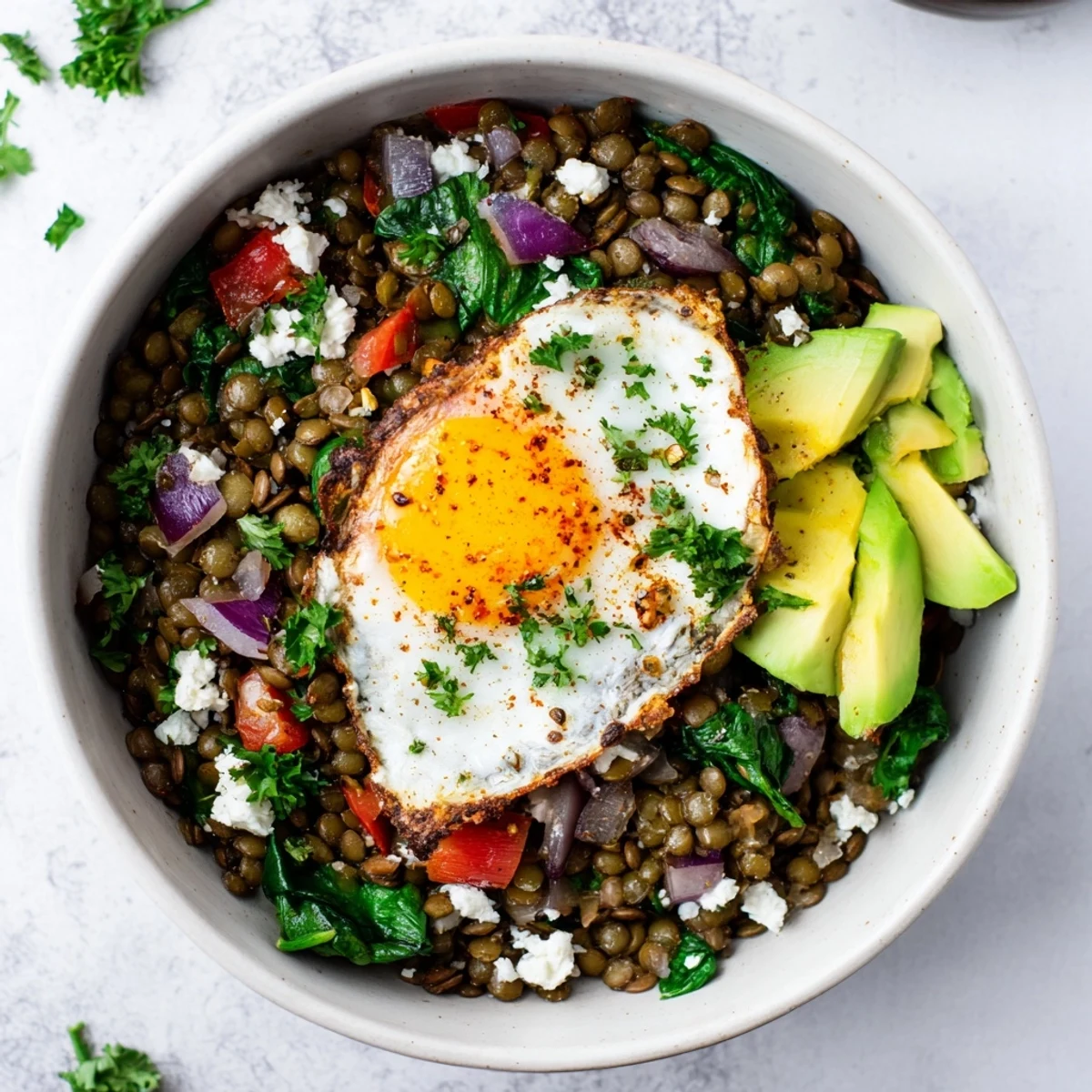 Steaming Savory Lentil Breakfast Bowl with sautéed vegetables and a perfectly poached egg.