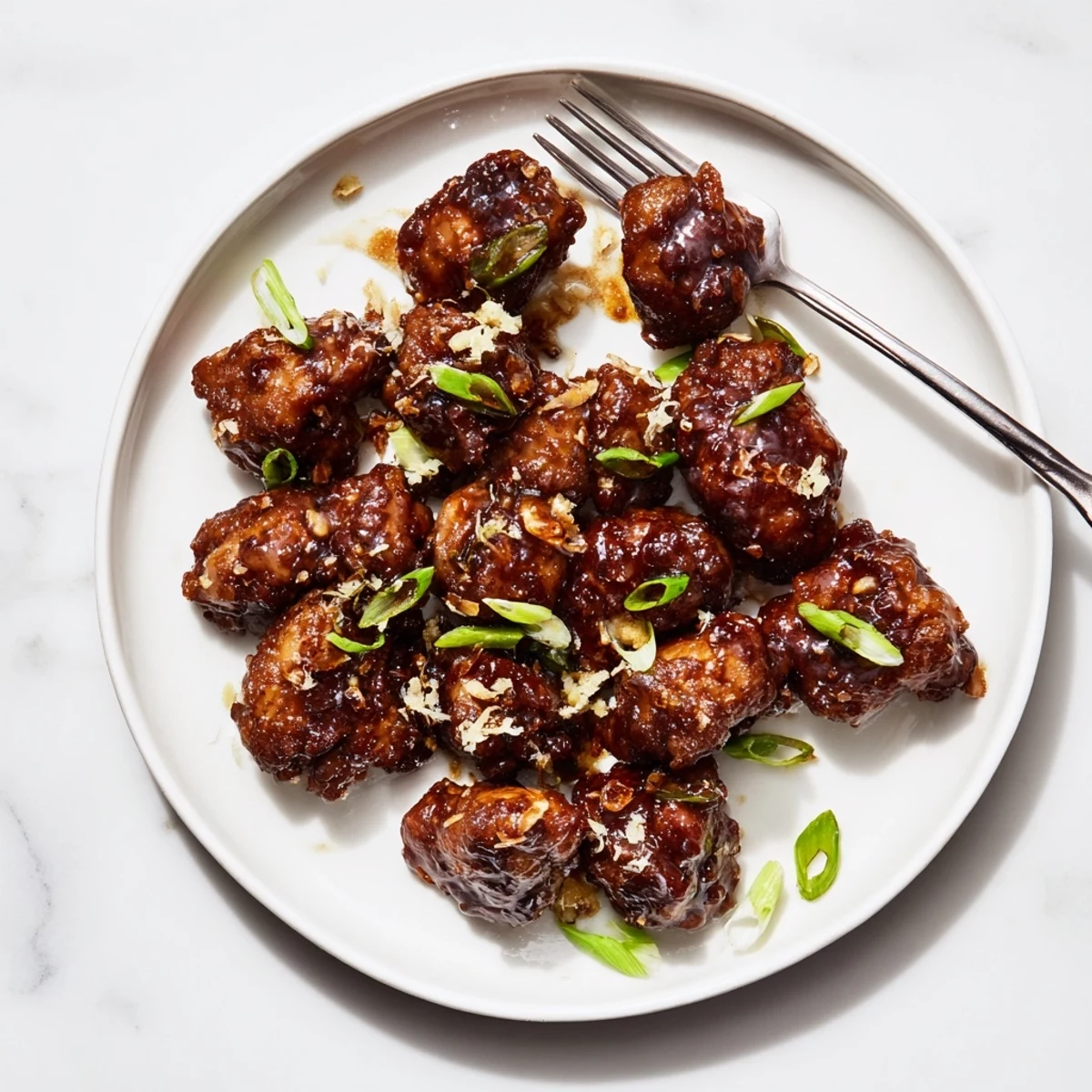Golden brown Mongolian chicken glazed in a shiny sweet and savory sauce with fresh green onion garnish