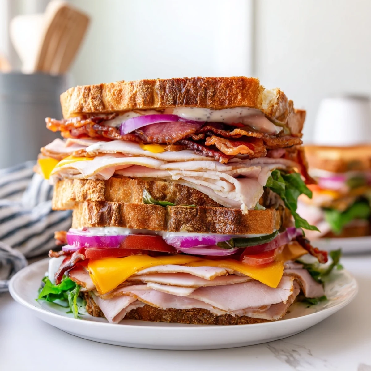 Hearty ultimate turkey beef bacon ranch sandwich served with pickles on a wooden board