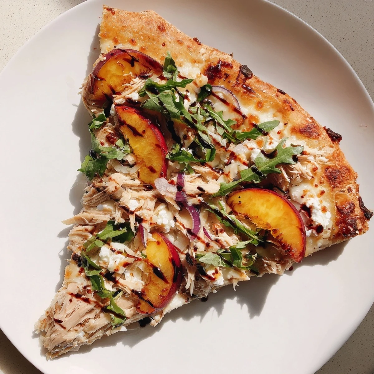 Crisp crust pizza loaded with chicken, peaches, ricotta cheese, arugula, and sweet balsamic drizzle