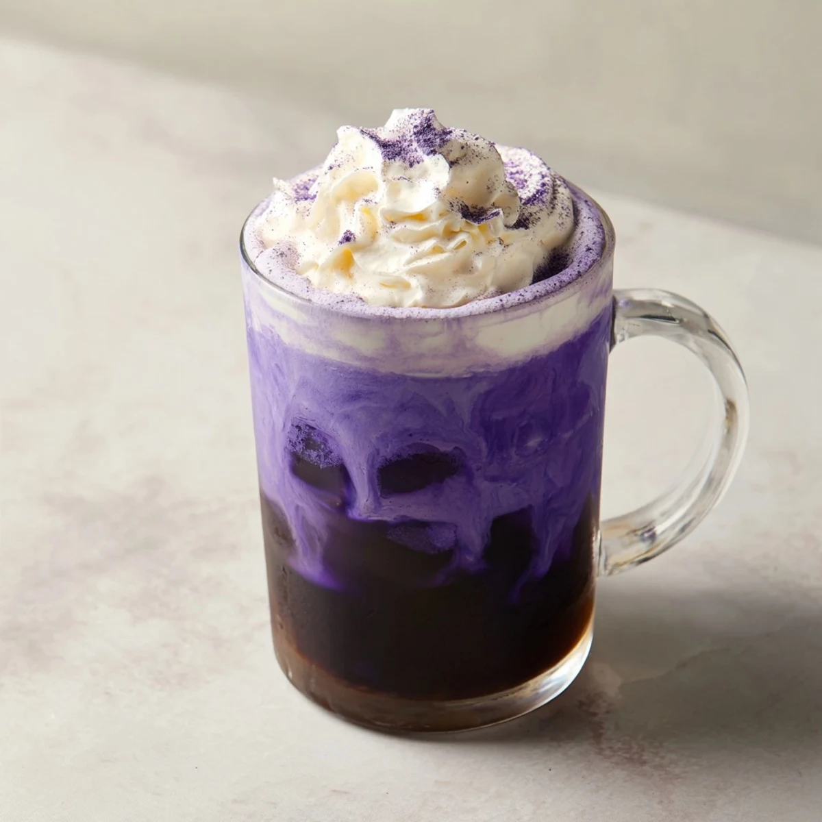 Creamy Filipino ube latte showcasing bright purple color topped with fluffy white foam