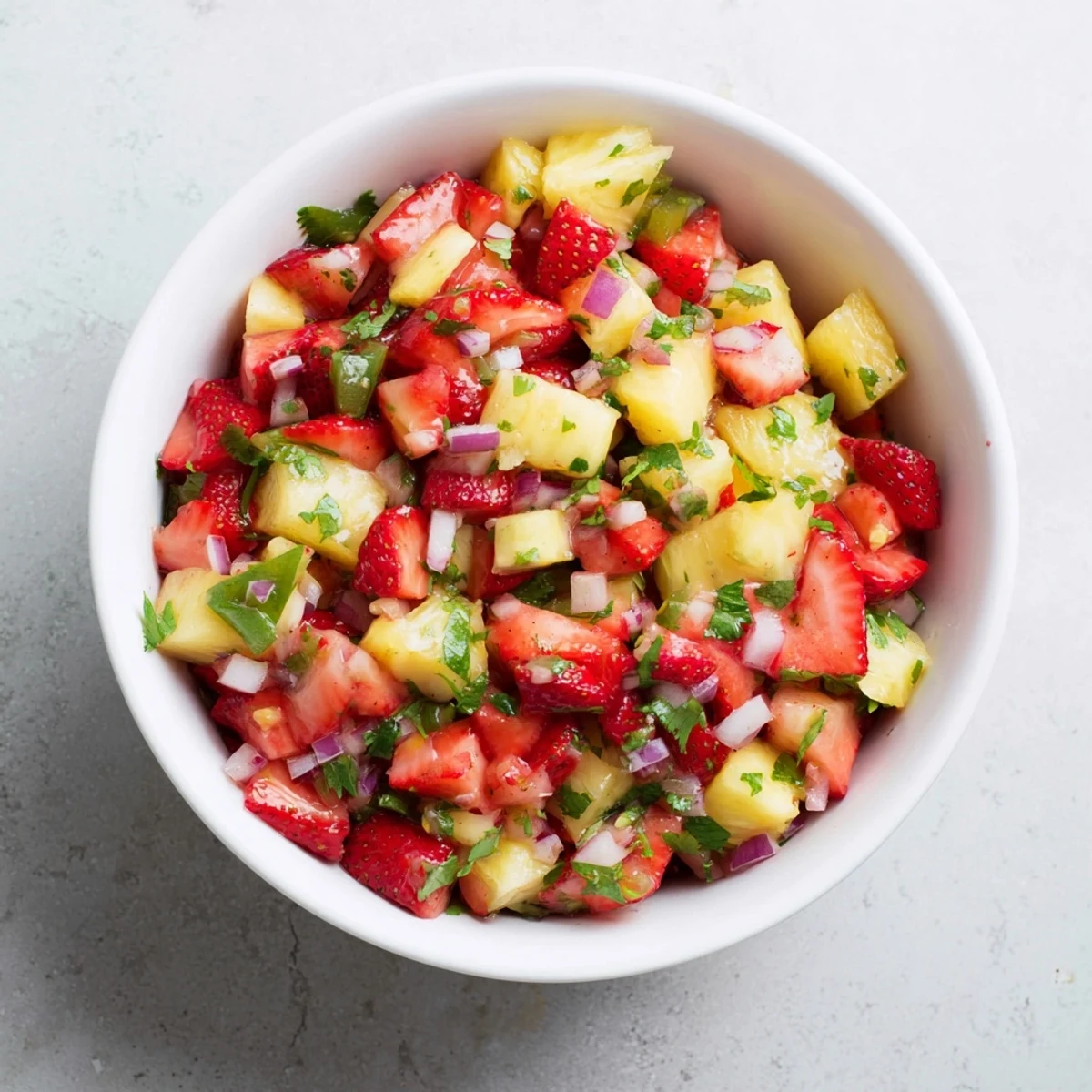 Vibrant homemade strawberry pineapple salsa featuring diced red strawberries golden pineapple chunks chopped cilantro and tortilla chips