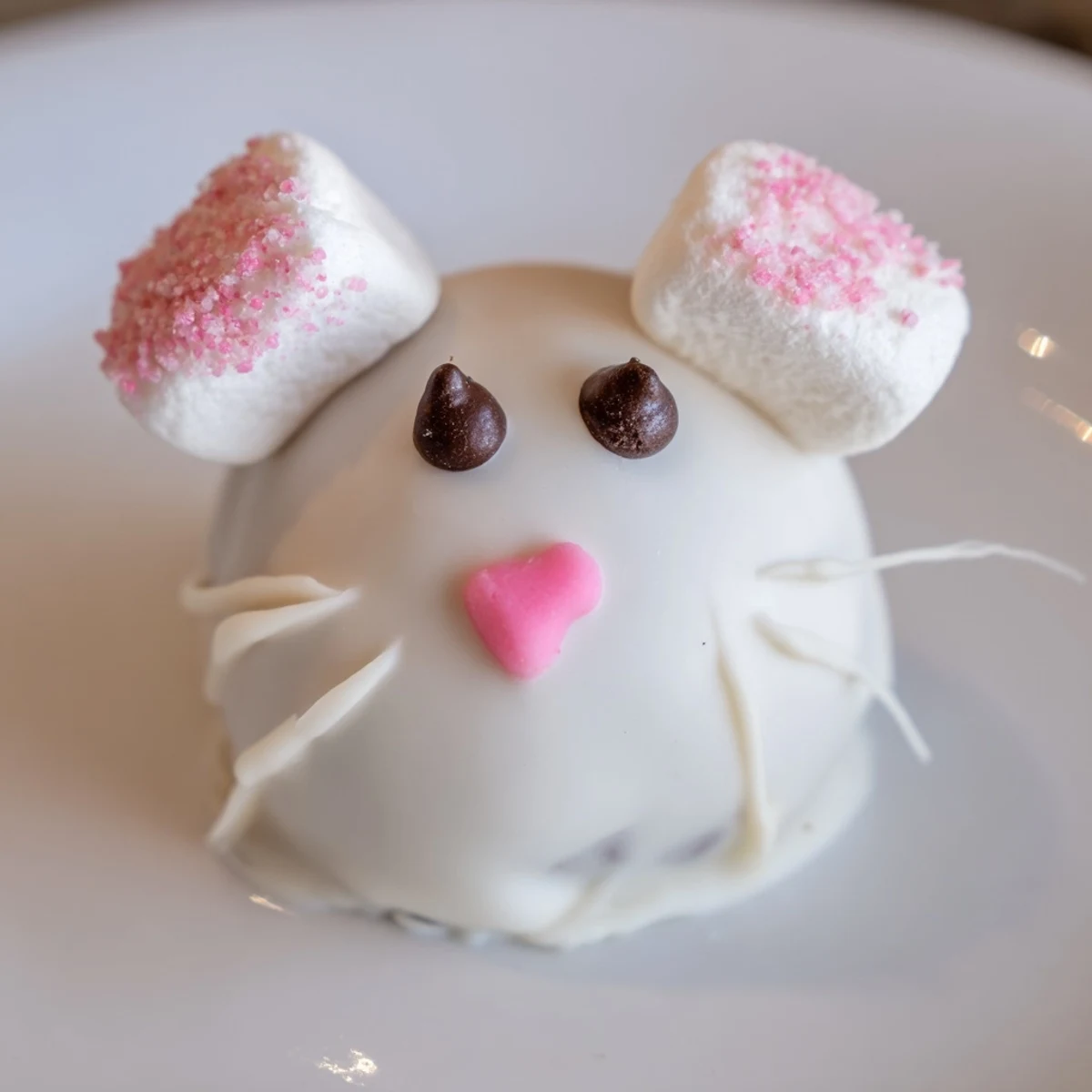 Plate of no-bake Bunny Oreo Balls with sanding sugar dusted marshmallow ears and heart sprinkle noses