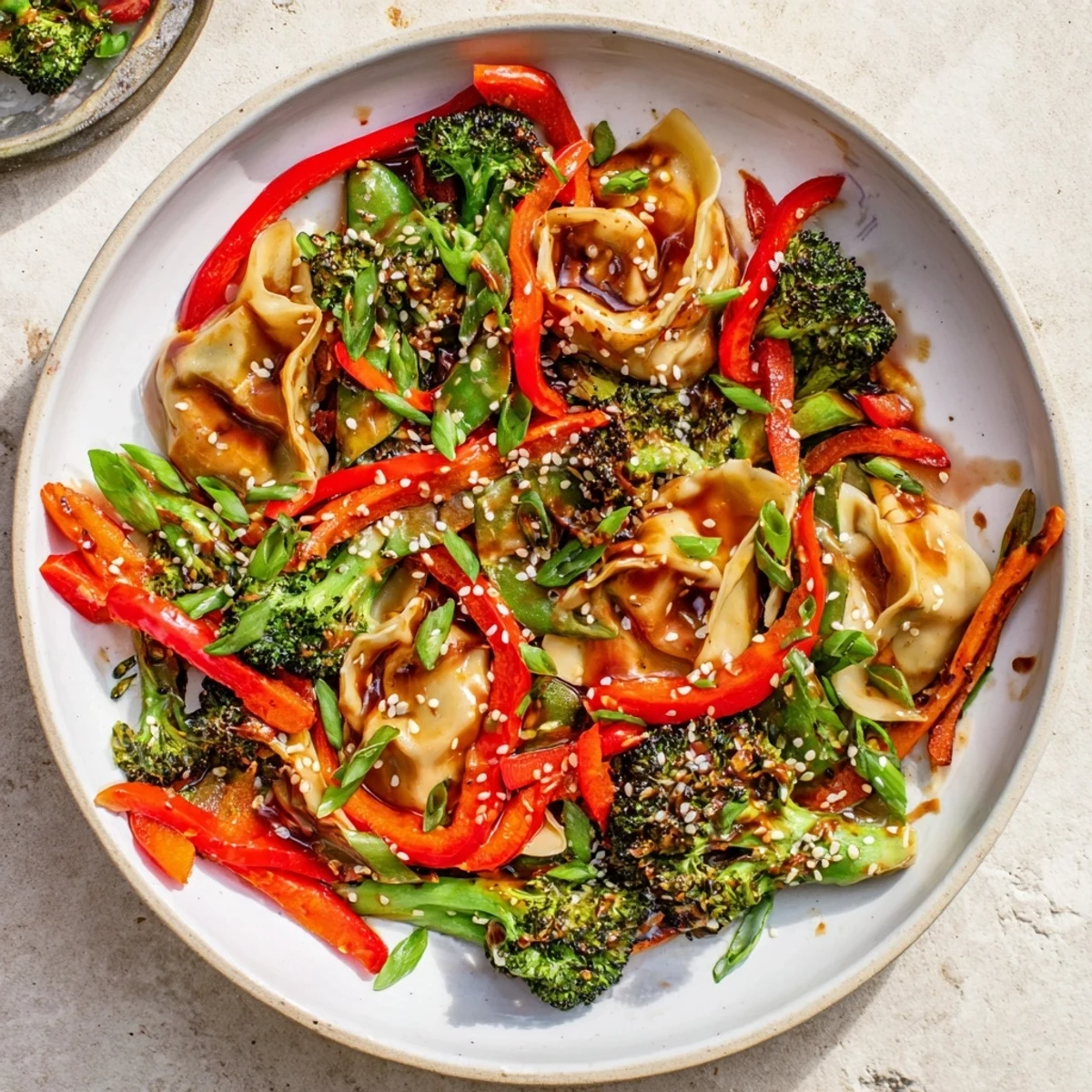 Golden pan-fried dumpling stir fry with colorful veggies coated in savory garlic sauce