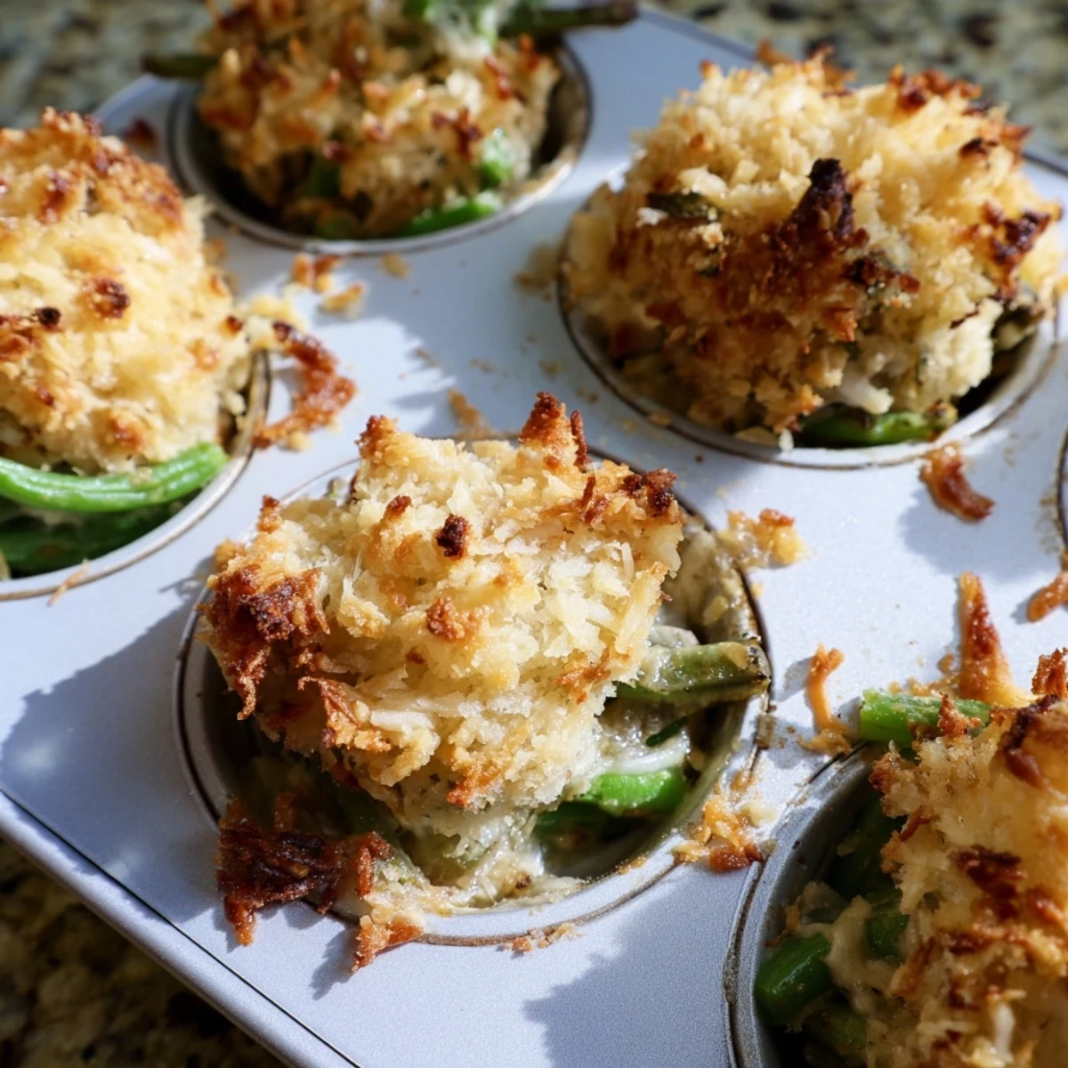 Individual savory garlic green bean casserole cups bubbling with melted Parmesan cheese