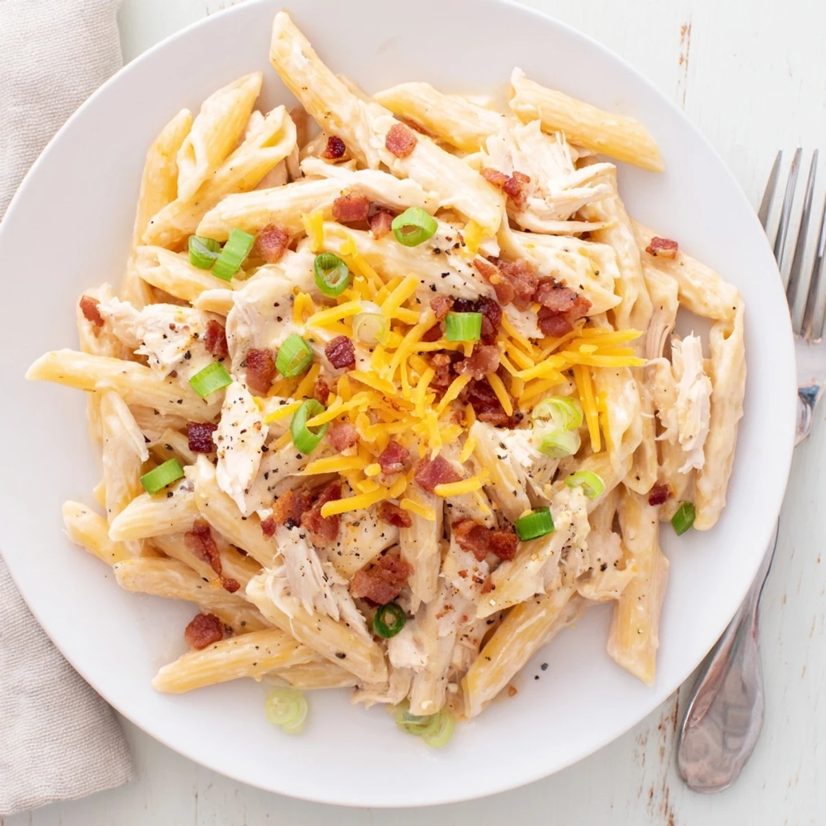 Creamy crack chicken pasta with melted cheese and crispy bacon garnish