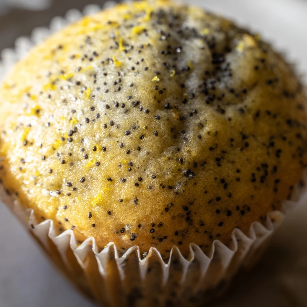 Golden Lemon Poppy Seed Muffins with domed tops fresh from the oven on a cooling rack