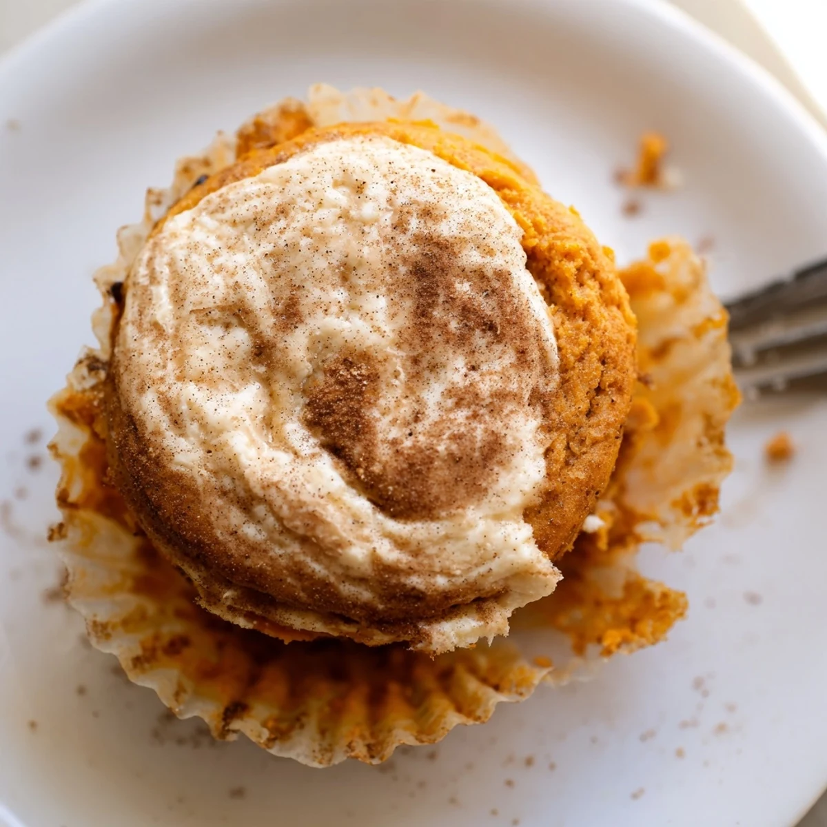 Warm chai pumpkin cheesecake muffins fresh from the oven showing moist pumpkin crumbs and creamy swirls
