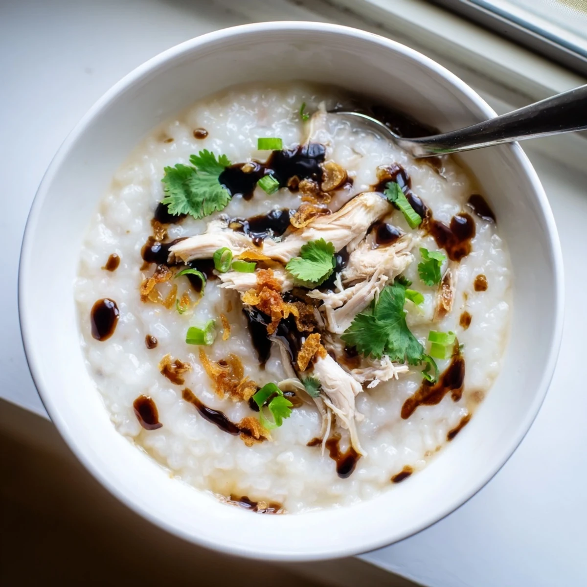 Comforting chicken congee porridge with shredded chicken and ginger slices served piping hot