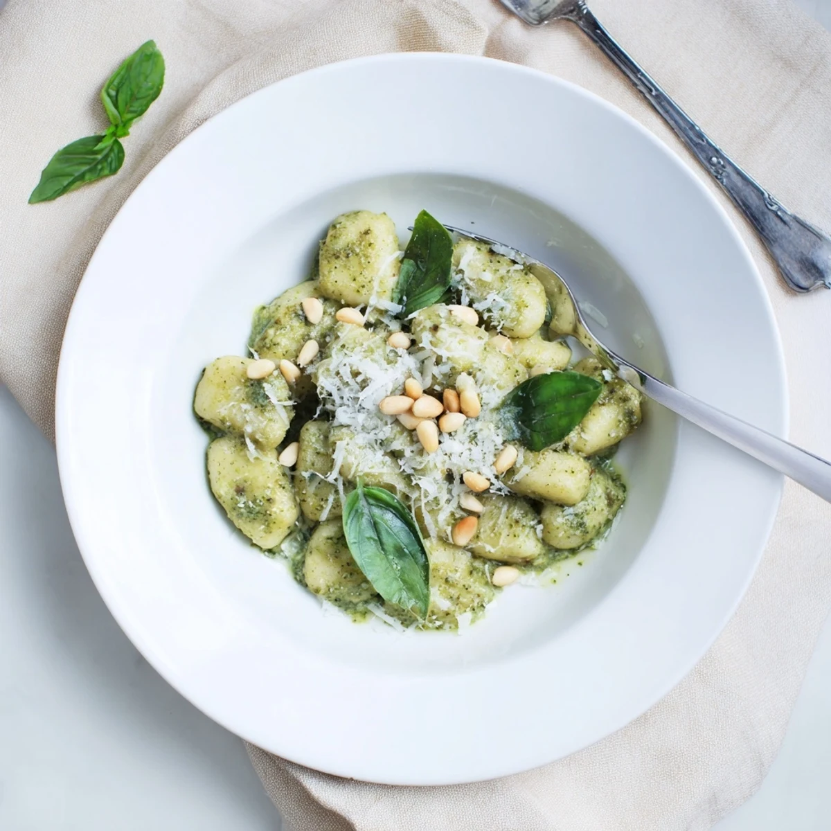 Italian potato dumplings swimming in a rich herbaceous sauce garnished with shaved Parmesan cheese