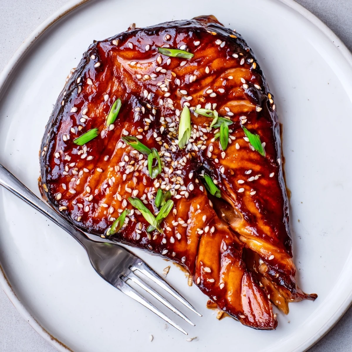 Oven-roasted Baked Teriyaki Salmon with caramelized edges, sesame seeds, sliced scallions.  