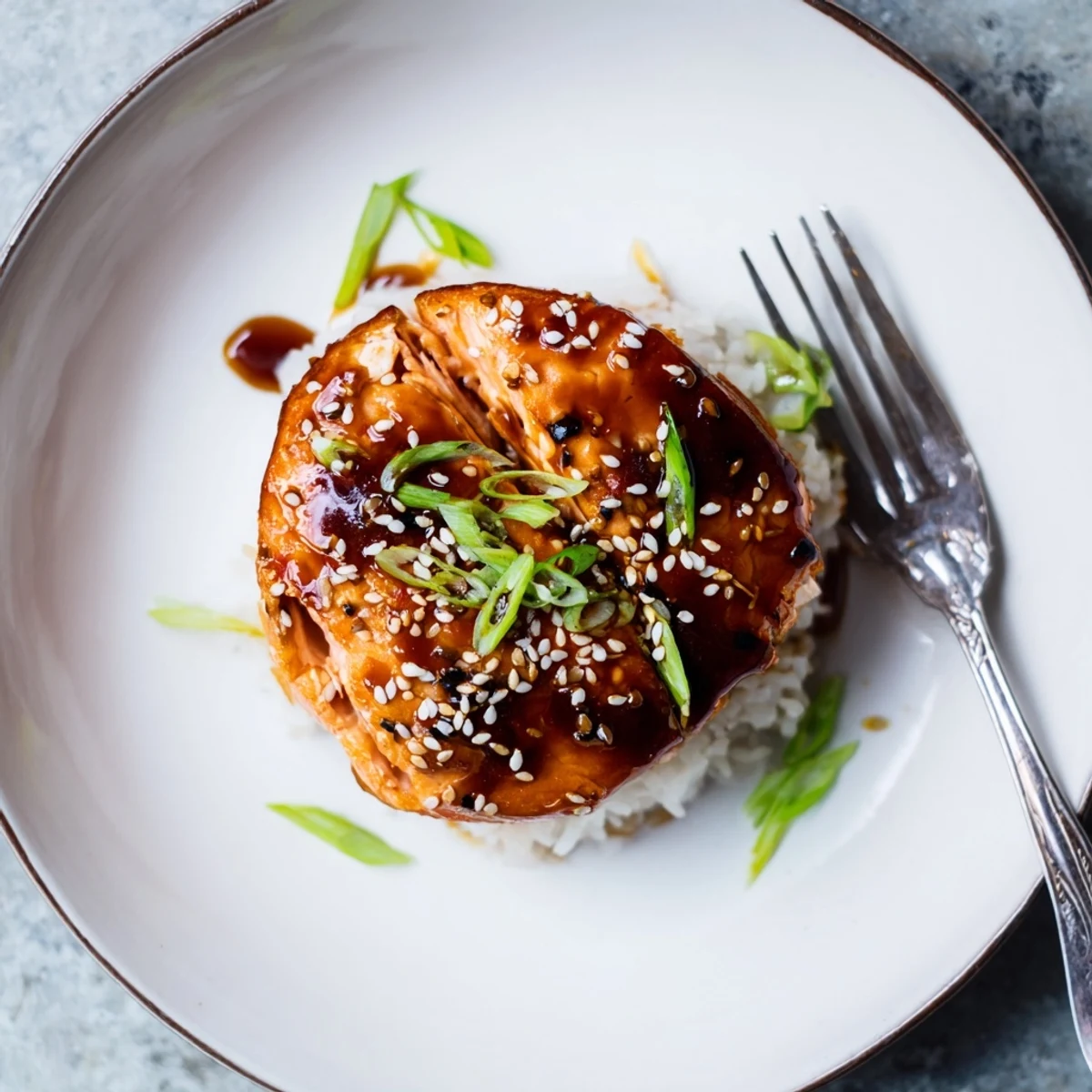 Baked Teriyaki Salmon topped with sticky, savory-sweet glaze, served with greens.