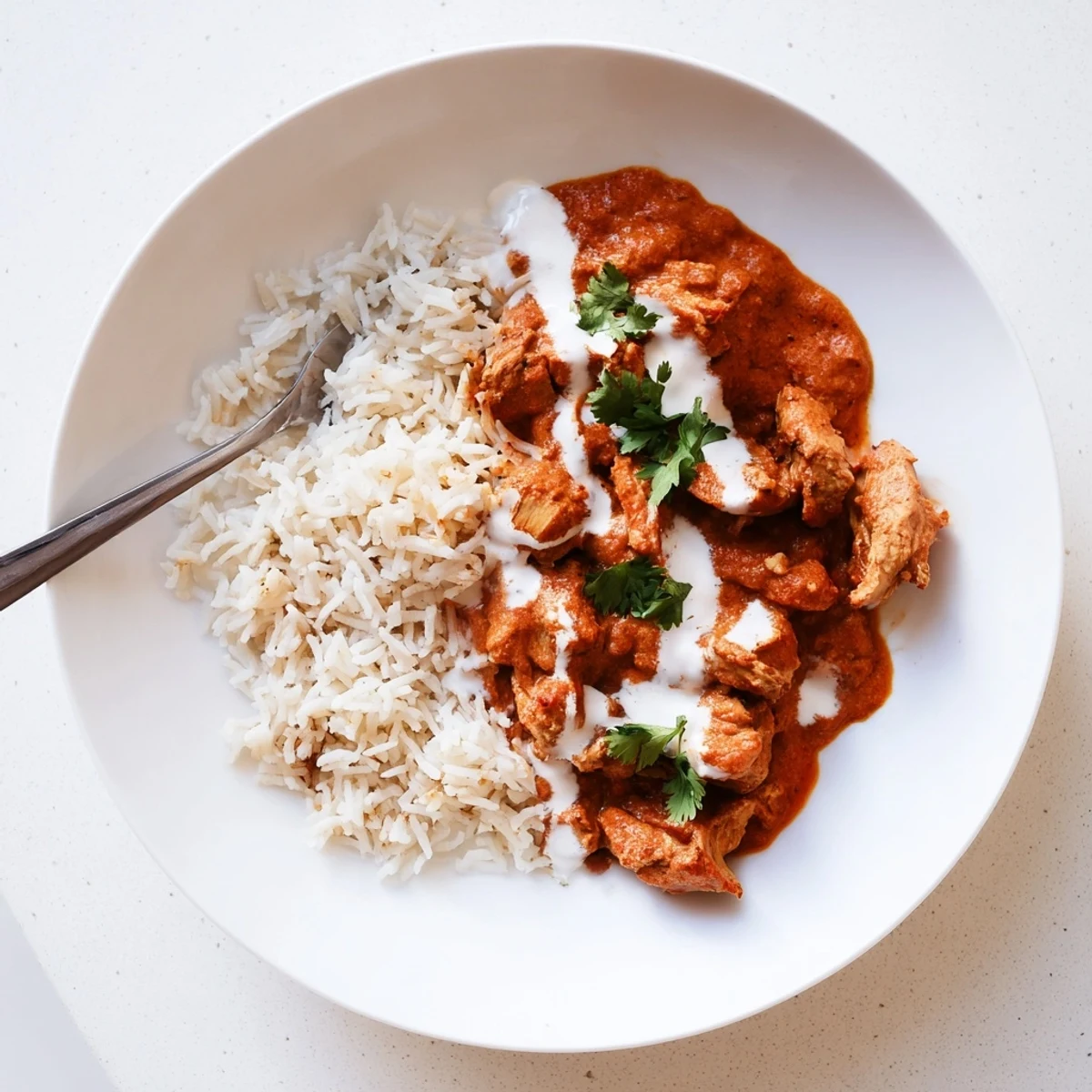 Warm Butter Chicken Indian Recipe ladled over fluffy basmati rice, aromatic.