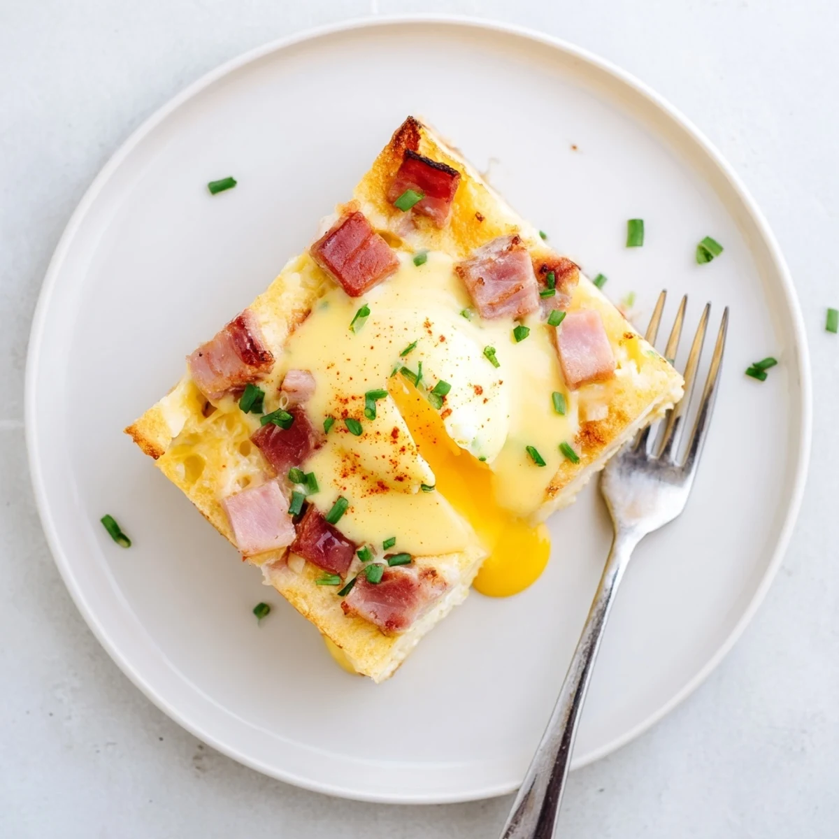 Baked Eggs Benedict Casserole with golden crust, creamy hollandaise drizzle, warm buttery aroma