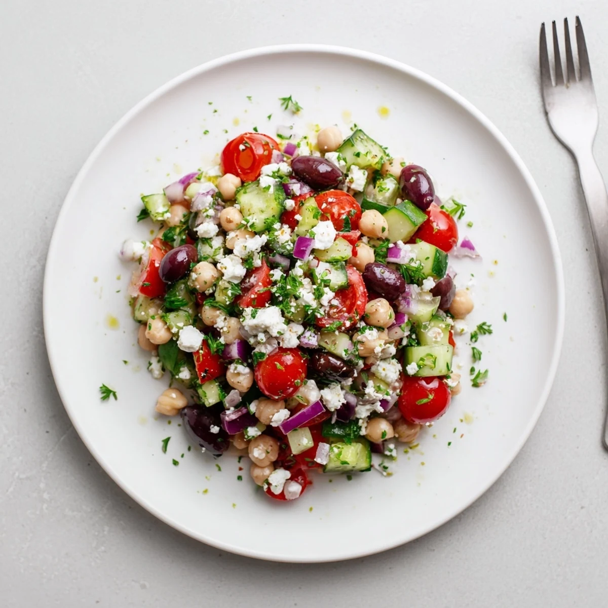 Fresh herbs and olive oil highlight the Mediterranean Chickpea Salad Recipe in a bowl