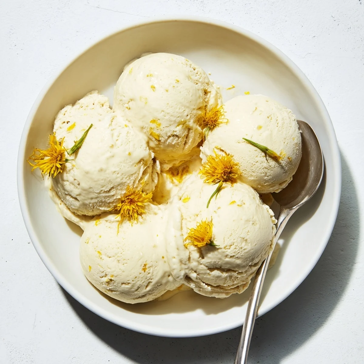 Homemade dandelion honey ice cream with a honey drizzle served on a rustic wooden board