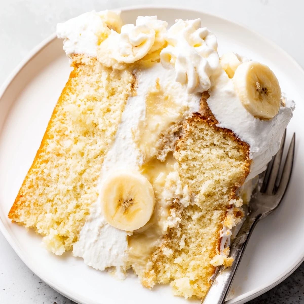 Classic Banana Pudding Cake Recipe chilled, crowned with whipped cream and wafer crumbs.