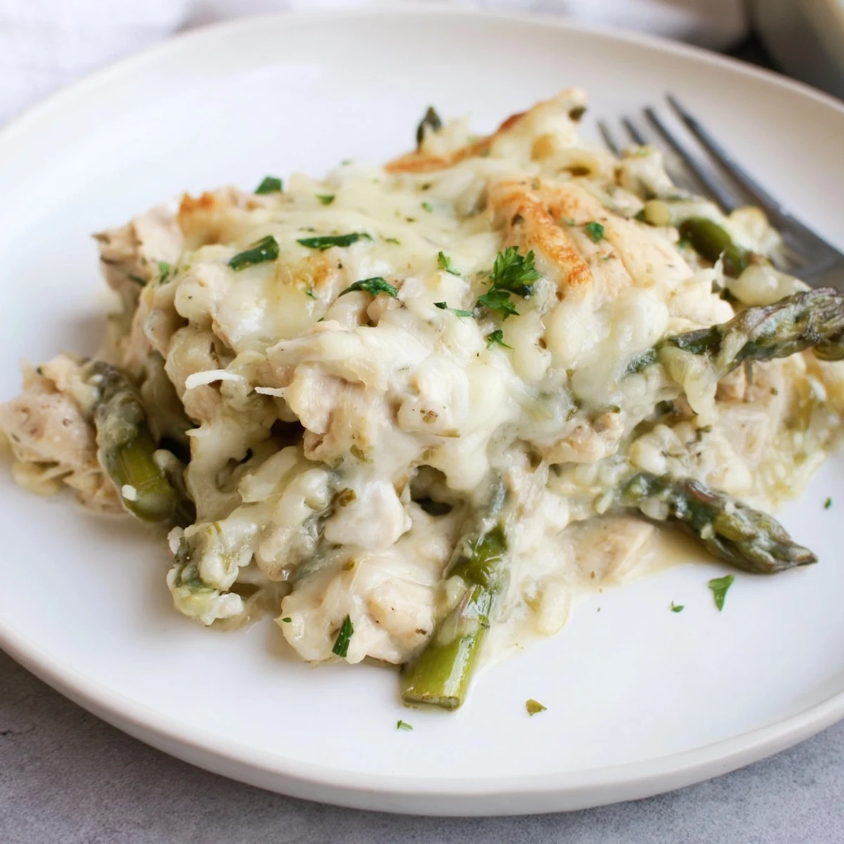 Golden, bubbling Creamy Chicken Asparagus Bake topped with melted mozzarella and parsley