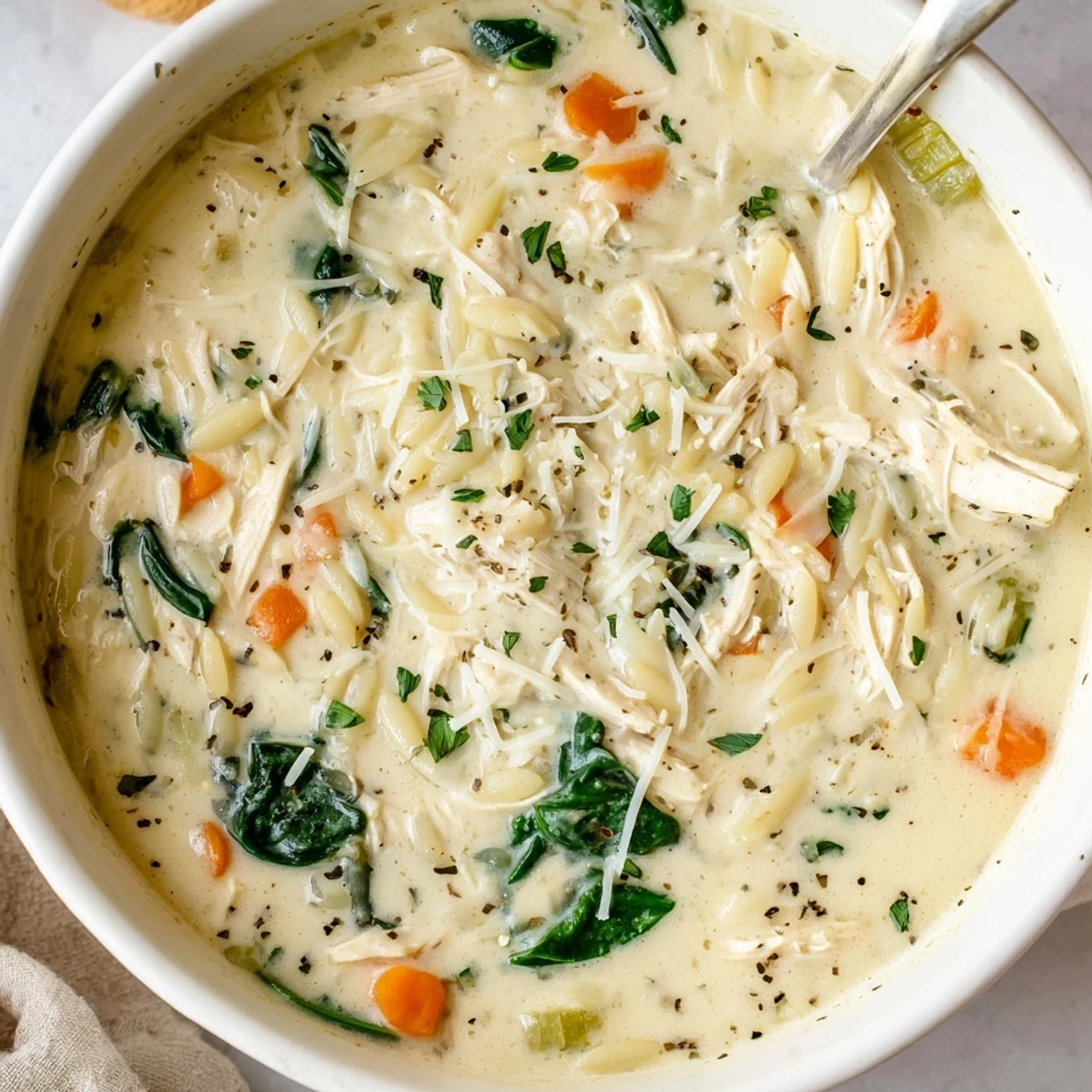 Bowl of Creamy Chicken Florentine Soup With Orzo, silky broth, nutmeg aroma