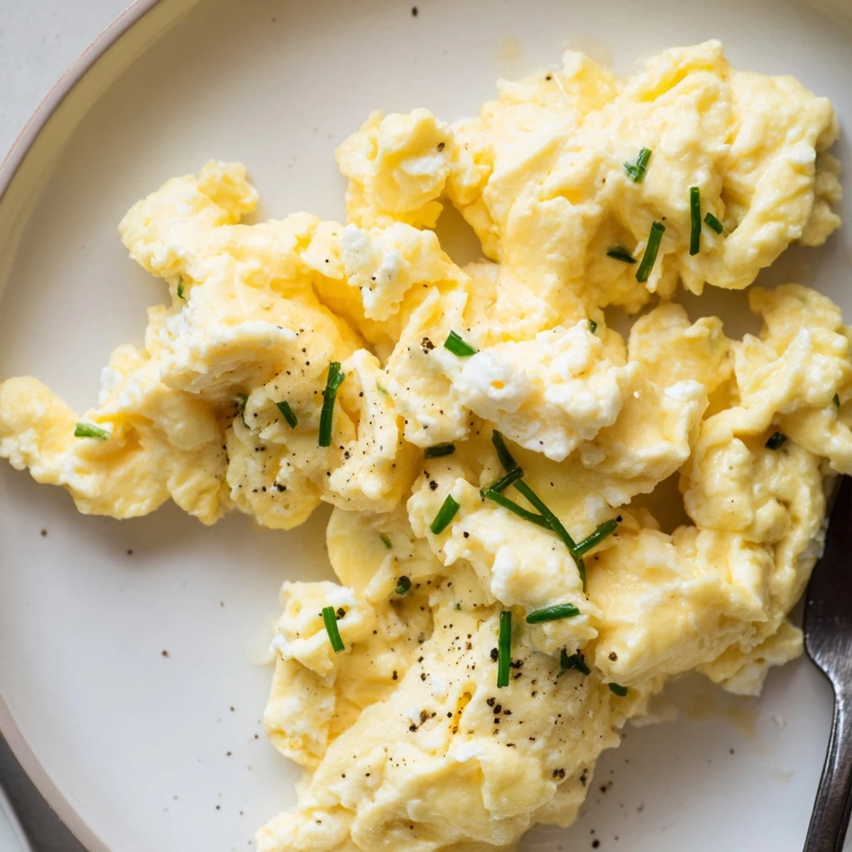 Creamy Cottage Cheese Scrambled Eggs with Chives, garnished with cracked black pepper
