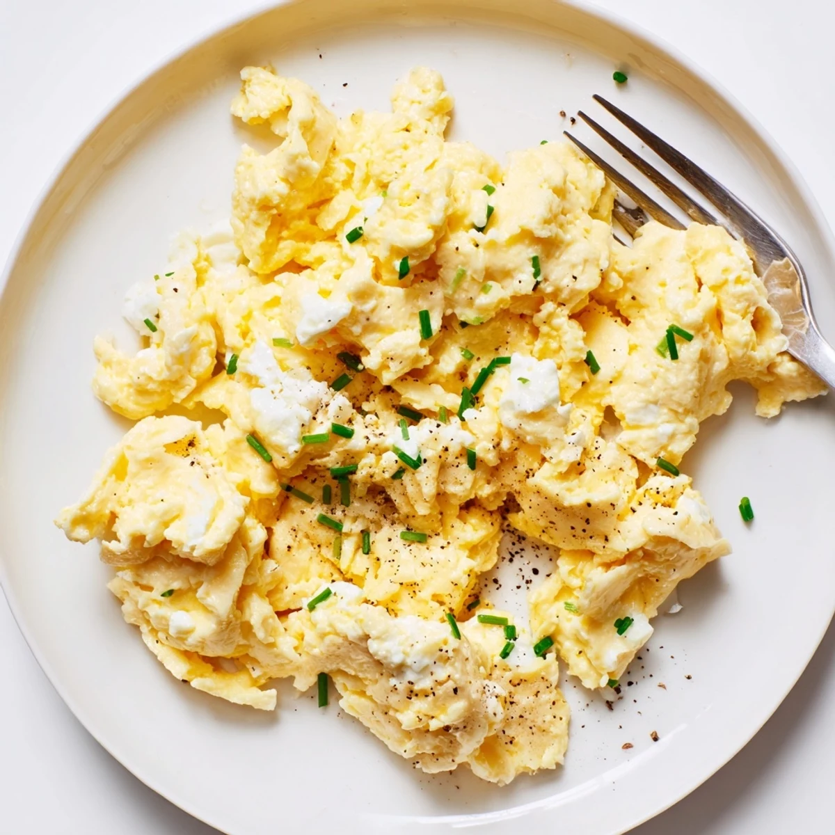 Fluffy Cottage Cheese Scrambled Eggs with Chives served alongside buttered sourdough toast
