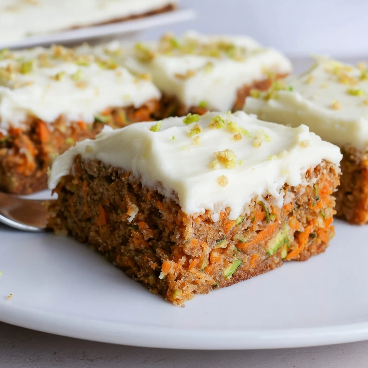 Warm slices of Spiced Ginger Carrot And Zucchini Bars With Lemon Cream Cheese Frosting