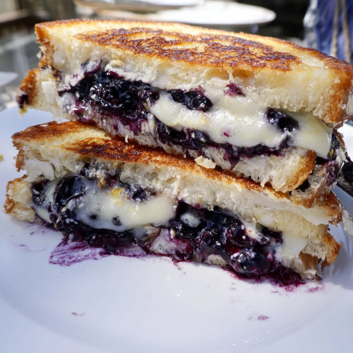 Warm Crispy Blueberry Grilled Cheese sliced diagonally, juicy berries and melted cheese