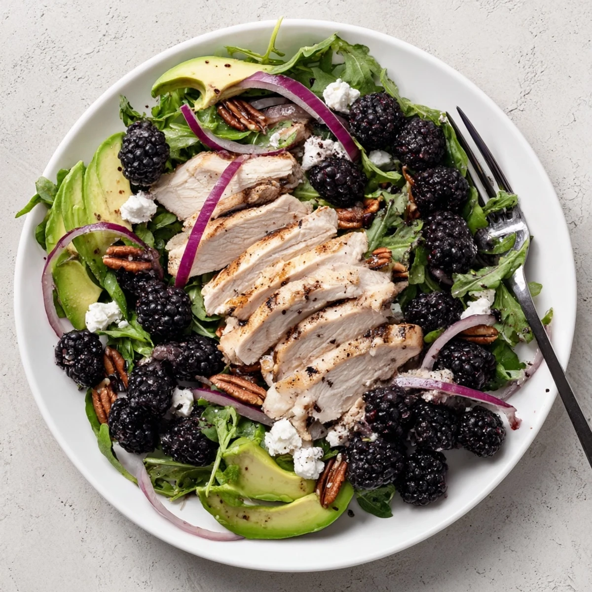 Grilled sliced chicken atop mixed greens in Sweet Tangy Blackberry Chicken Salad Recipe