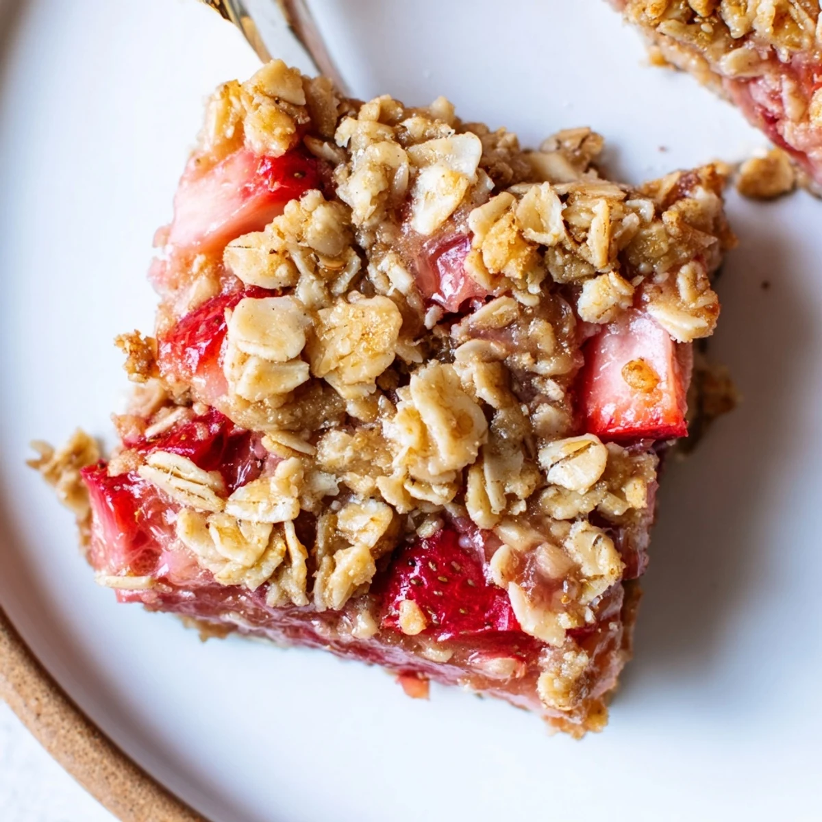 Strawberry Rhubarb Crumble Bars with golden oat topping and juicy bubbling filling