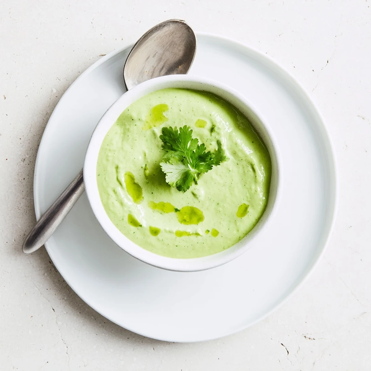 Smooth and tangy Mexican-inspired creamy sauce with visible cilantro flecks in a glass serving dish