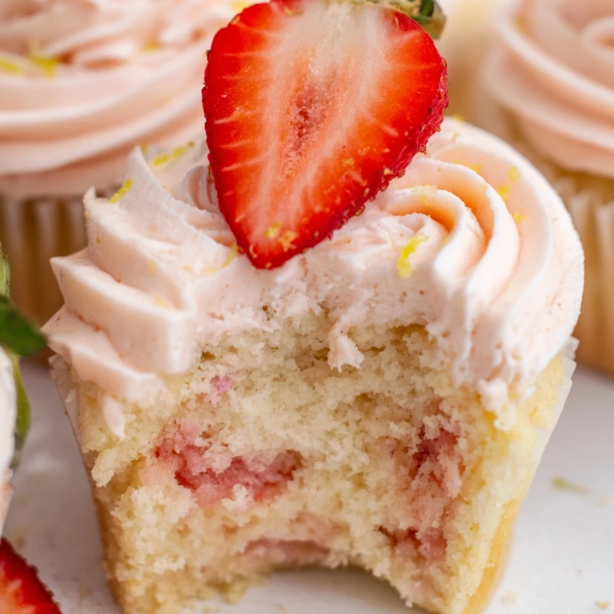 Light fluffy strawberry lemonade cupcakes with zesty lemon zest and creamy swirled frosting