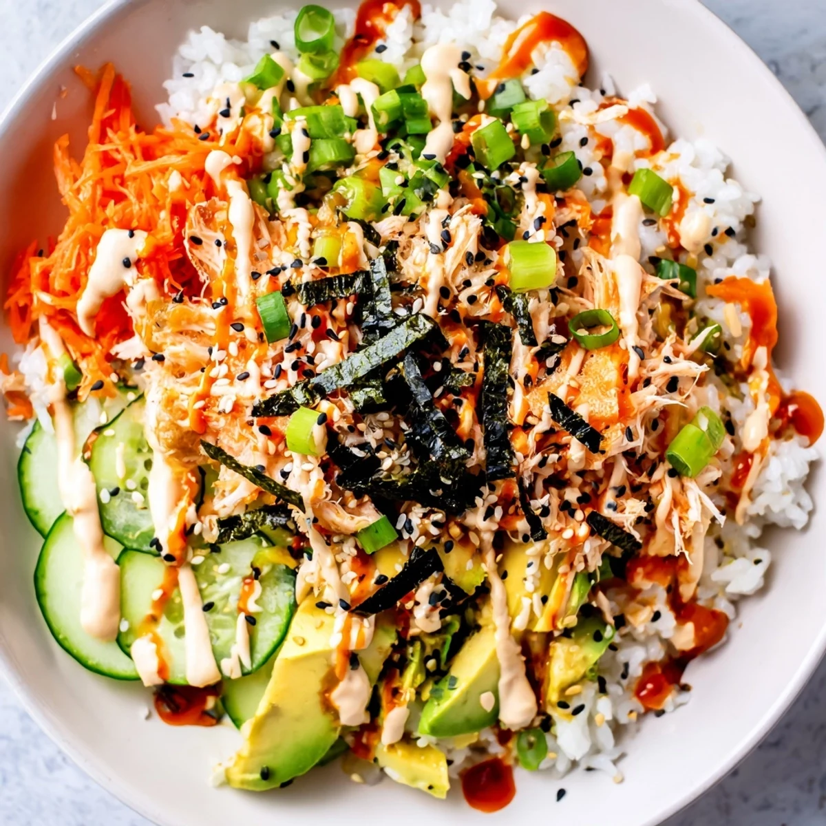 Deconstructed California roll sushi bowl arranged with fresh toppings over seasoned rice in white bowl