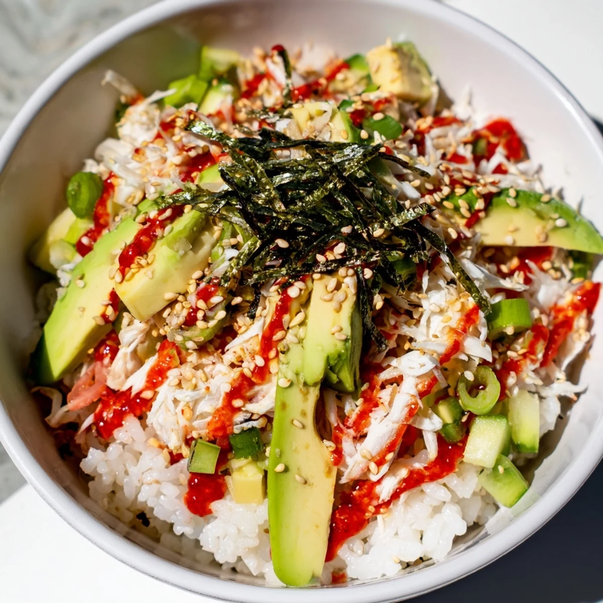 Easy California roll sushi bowl featuring shredded crab creamy avocado and crisp cucumber garnish